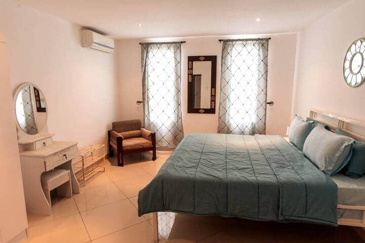 (Chambre principale) Chambre 3 au 3e étage - Grand lit Queen Size, commode, fauteuil, armoire, table de travail et chaise.