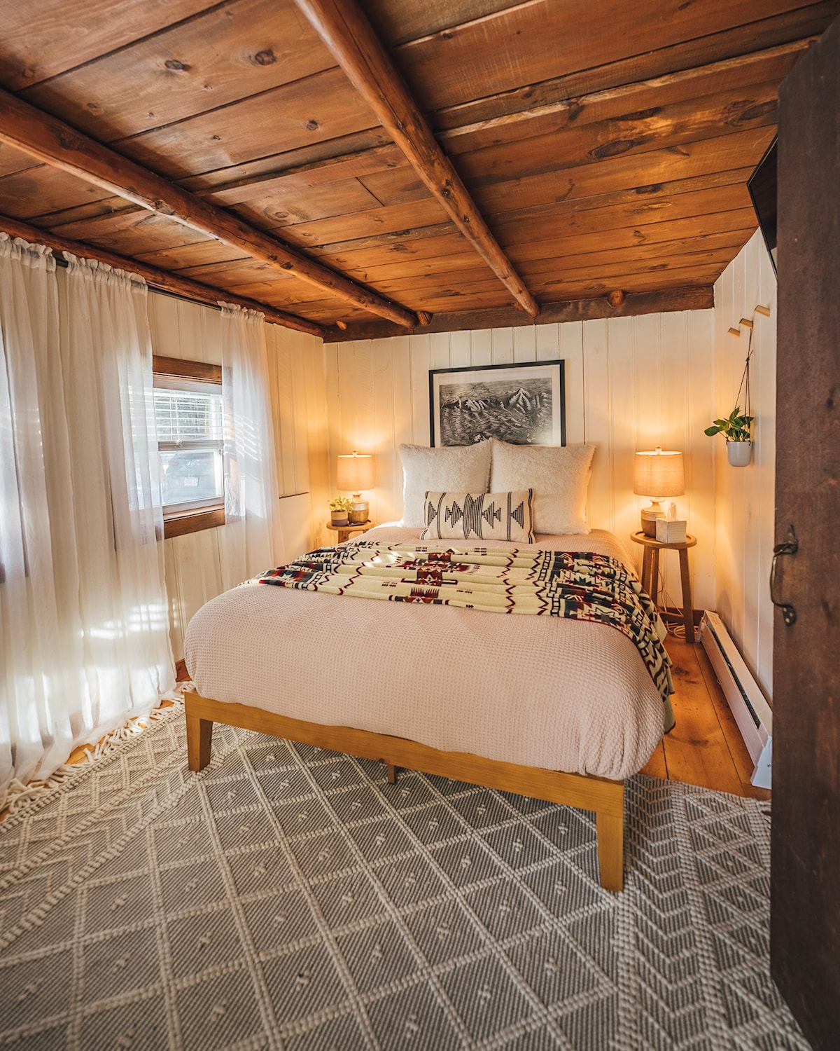 Wake up feeling refreshed in this cozy cabin bedroom. The comfortable queen mattress and 4+ pillows provide a rejuvenating night's sleep. Enjoy your favorite show on the TV or curl up with a good book. Nightlight, fan, blinds and plants included.