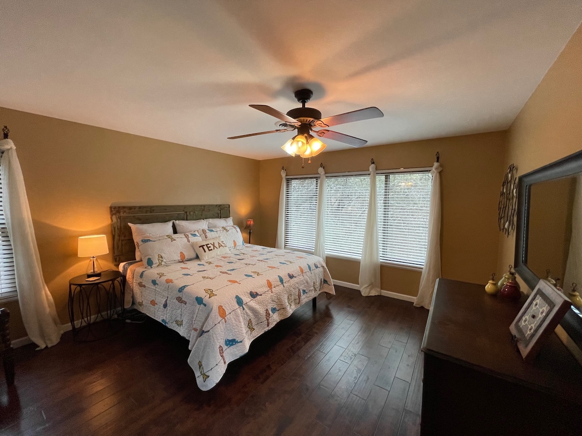 غرفة نوم أساسية مع حمام خاص وسرير بمقاس كبير في الطابق العلوي