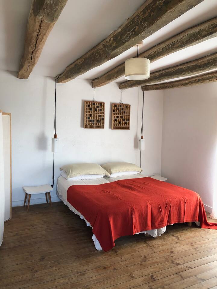 Otvorena spavaća soba s bračnim krevetima s pogledom na prednji vrt.