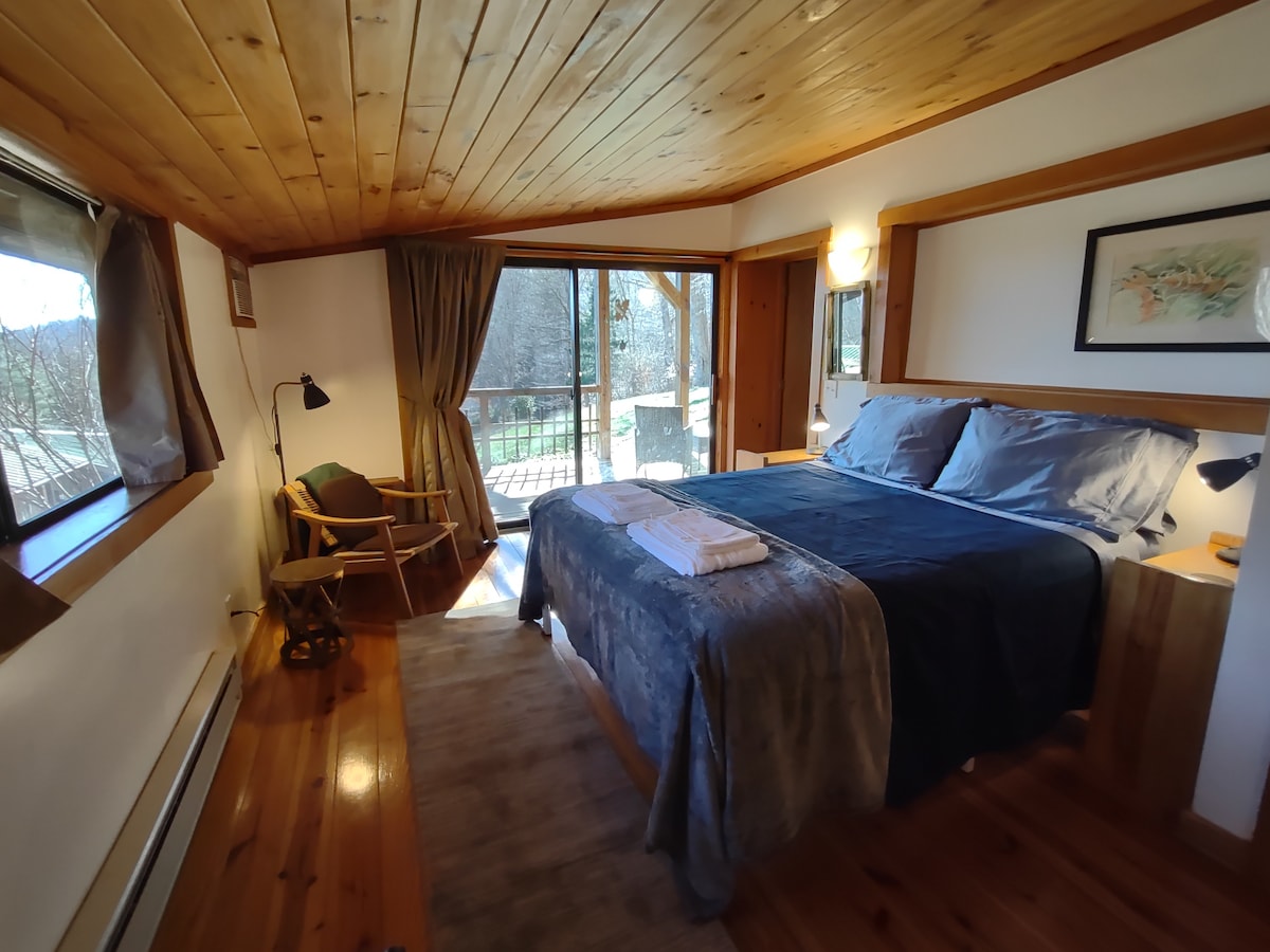 De  slaapkamer ligt het dichtst bij de keuken, met queensize bed en toegang tot de veranda aan de achterkant.