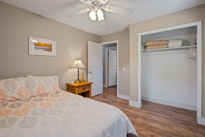 Chumba kikuu cha kulala cha ghorofa #3 kilicho na kitanda cha ukubwa wa malkia, tani za mwanga wa asili na sehemu ya kabati.