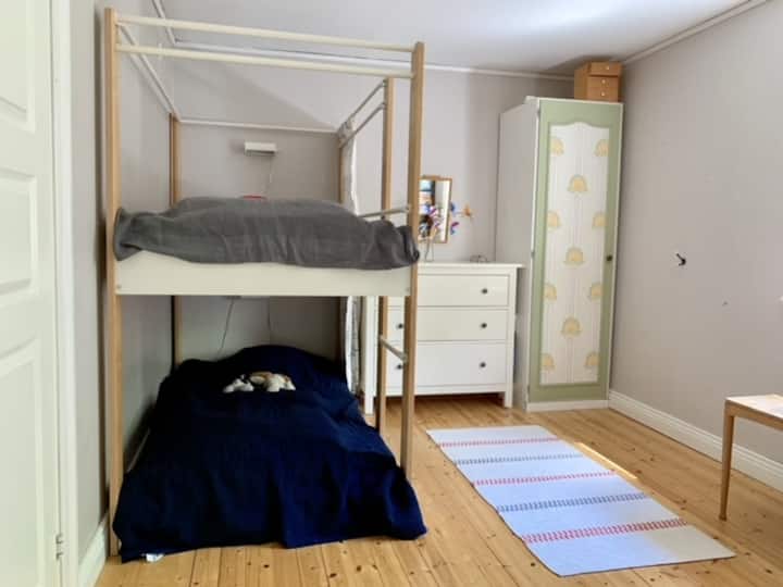 Chumba cha kulala ndani  ya nyumba, vitanda viwili kwenye kitanda cha ghorofa kilicho na magodoro thabiti na yenye starehe. Pia kuna kabati kubwa lakini vitabu, midoli na michezo ambayo unakaribishwa kutumia. 
Hiki ni chumba cha kutembea ambacho mtu anapitia ili kufikia chumba kingine cha kulala. 