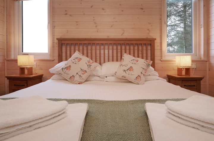 The master bedroom at Ben Klibreck Lodge. This comfortable double room has an en-suit shower room and built in wardrobes.
A wooden cabin with hot tub. 2 Bed-room (sleeps 4). Burgie woodland lodges.