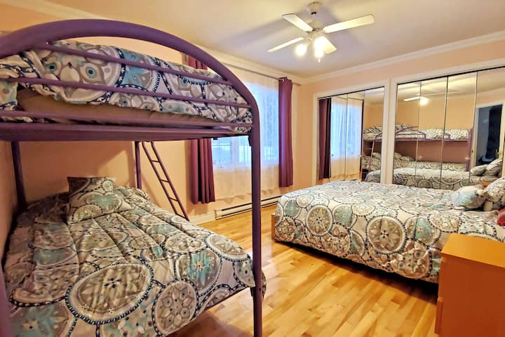 1号卧室配有标准双人床和两张单人双层床/1号卧室，配备1.8米宽双人床和1张双层床