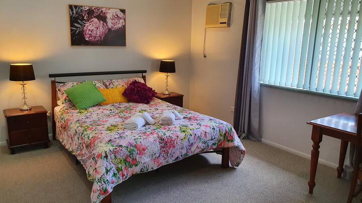 Large bedroom with Queen bed and desk with built in wardrobes and split system A/C.