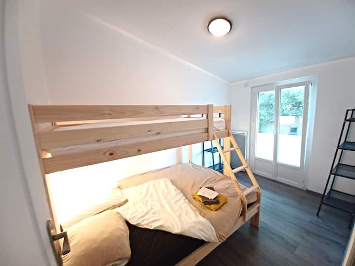 Spálňa s manželskou posteľou a samostatnou poschodovou posteľou. S výhľadom na balkón s výhľadom na more. 