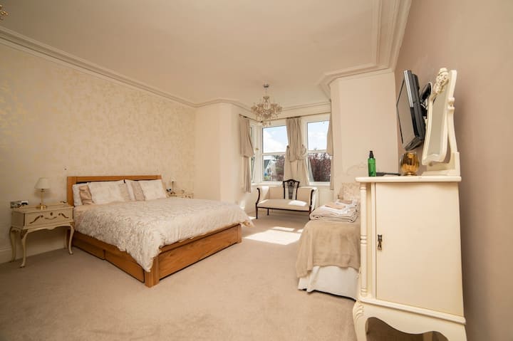 Very large Master bedroom (family room) with en suite shower room and wall mounted TV and antique furniture