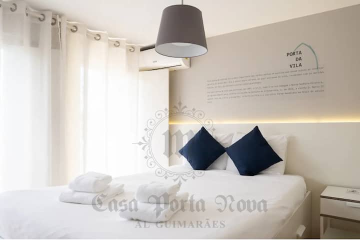 Dormitorio con cama matrimonial, armario y balcón.