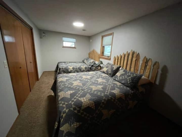 غرفة بالطابق السفلي تضم سريرين كوين