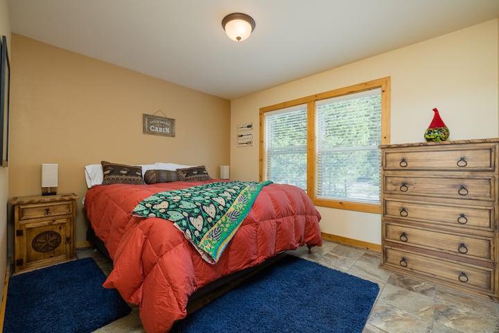 Chambre avec lit King Size et commode au rez-de-chaussée.