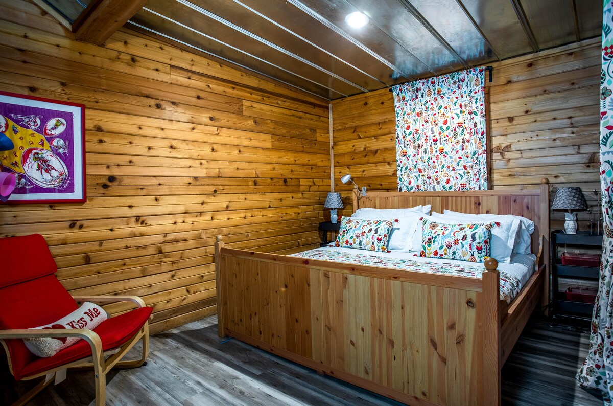 Kitanda cha kipekee cha aina ya mbao aina ya king ndicho kitovu cha chumba kikuu cha kulala.