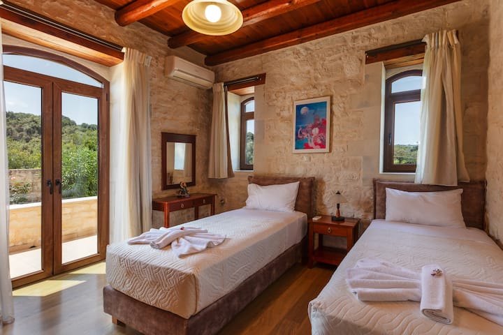 Ground floor bedroom with two single beds that can be converted into a king-size bed upon request & private balcony access.







