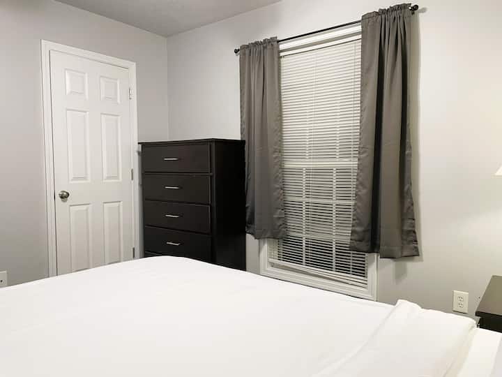 Bedroom #3 with queen bed and closet and a stack of drawers.