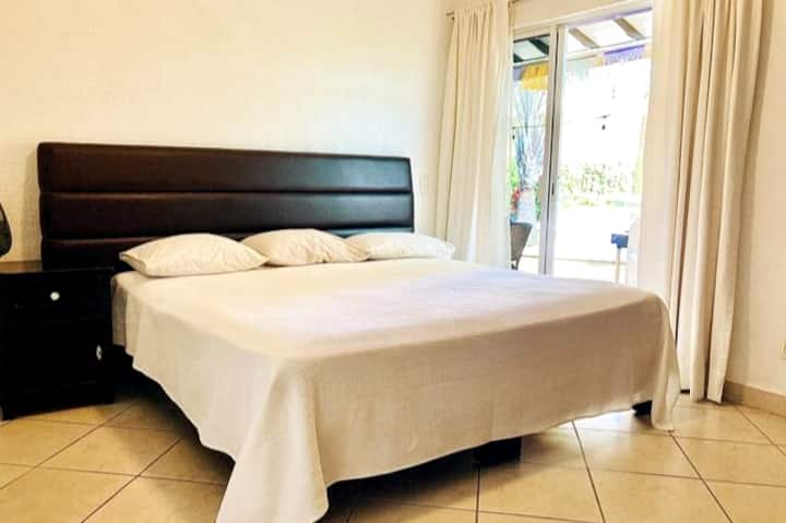 غرفة نوم ثانية بسرير كبير الحجم ومروحة سقف