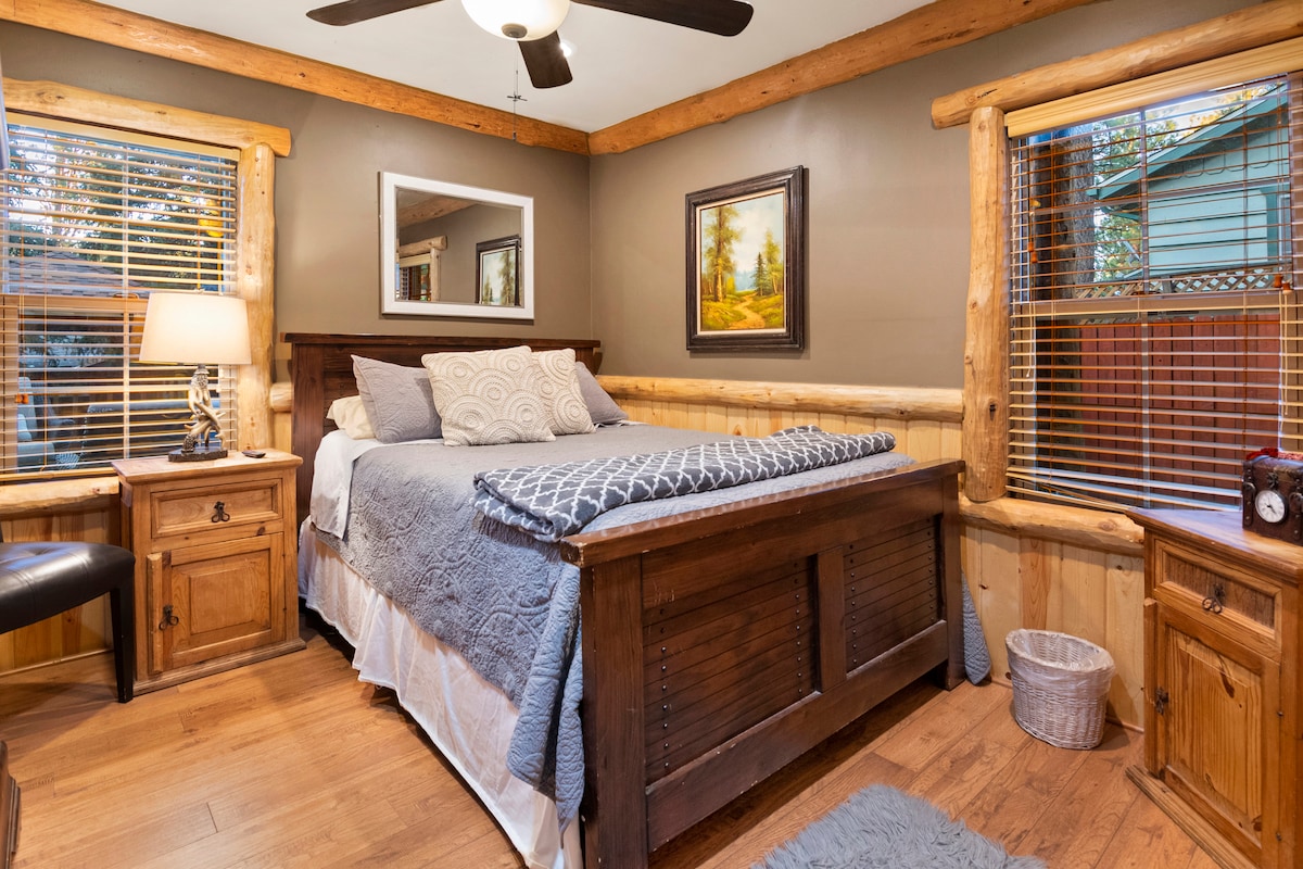 El dormitorio de la planta baja tiene una cama tamaño queen, armario, TV, lámpara, ventilador de techo y mesita de noche.