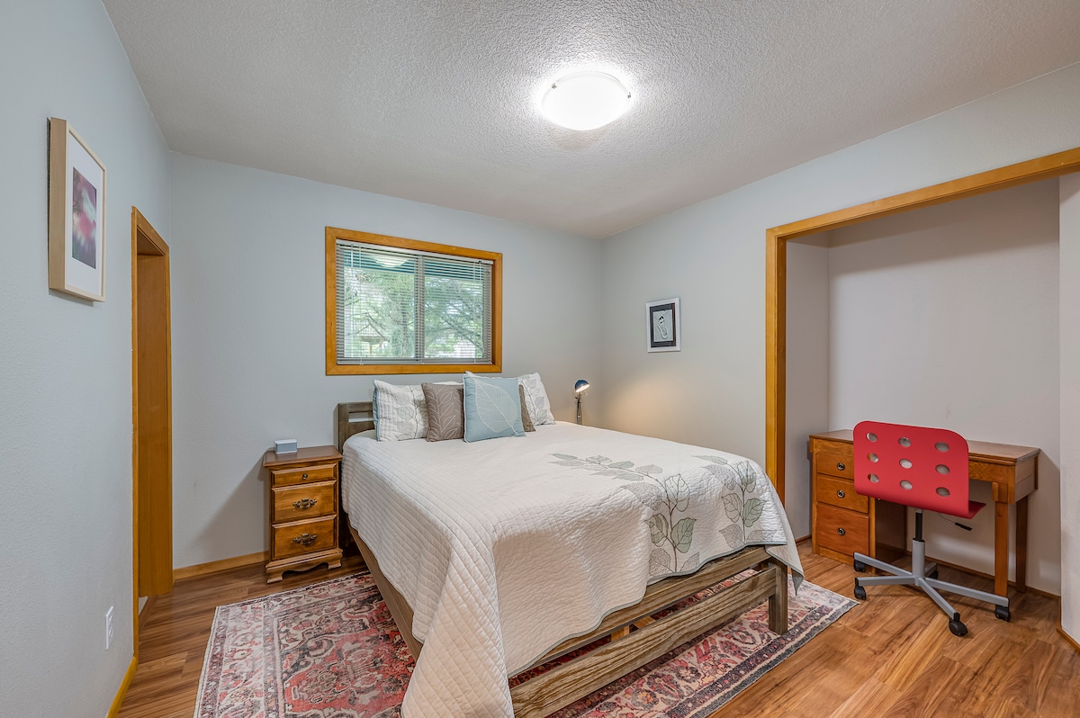 غرفة نوم كبيرة في الطابق السفلي مع مكتب وخزانة تحت الدرج. 