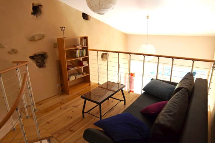 Мецанин на пастелната вила с разтегателен диван.