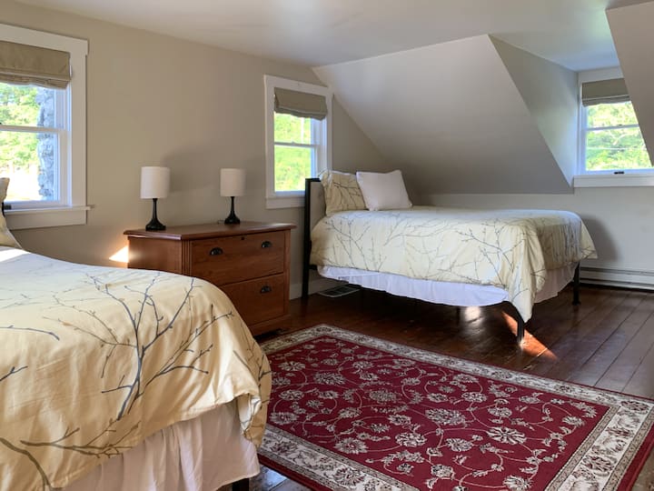 Quarto 1 no andar de cima com duas camas de tamanho completo e cômodas.