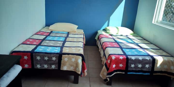 Room 3 features two single beds , ceiling fan 