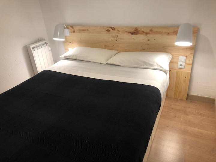 ห้องนอนพร้อมเตียงคู่พัดลมเพดานเครื่องทำความร้อนไฟฟ้าและตู้เสื้อผ้า