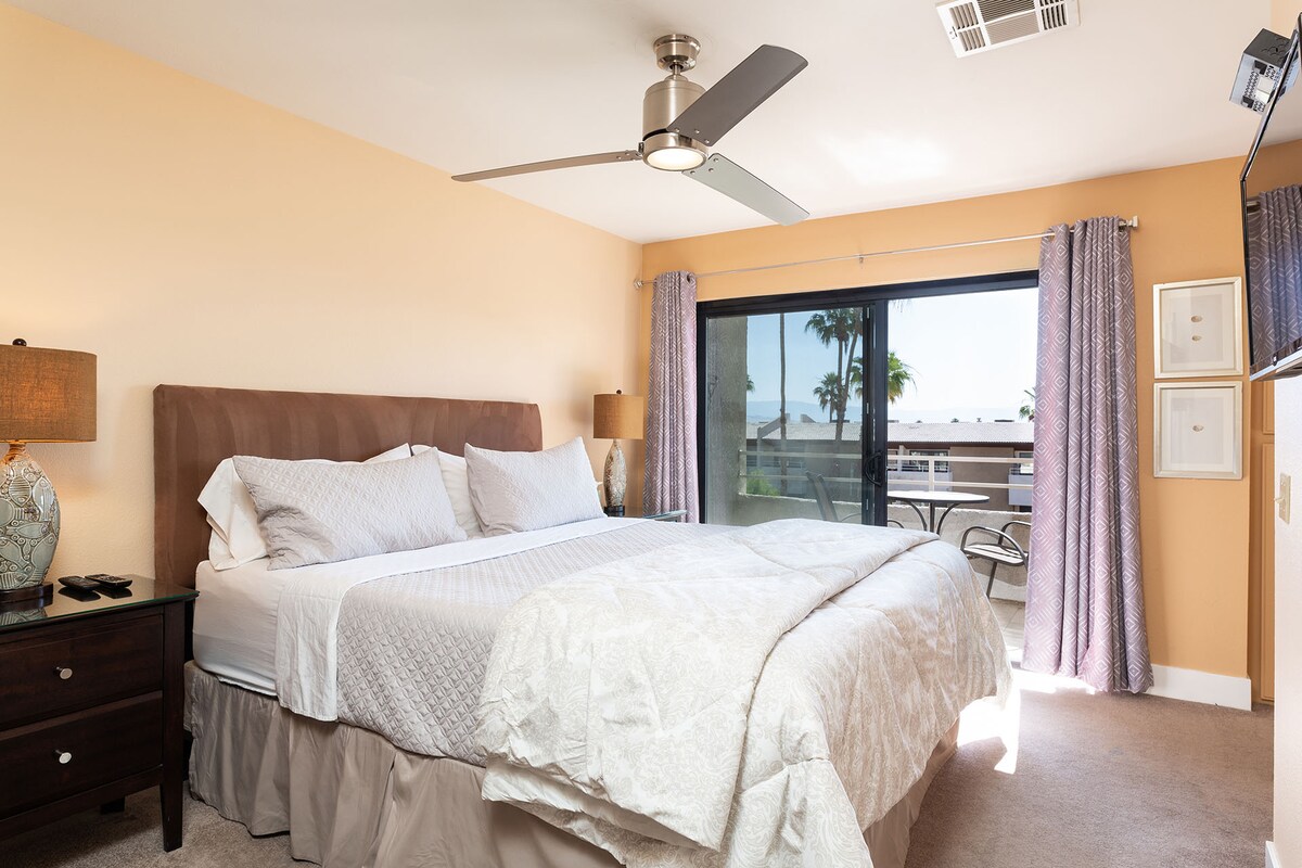 Dormitorio con cama tamaño king y balcón.