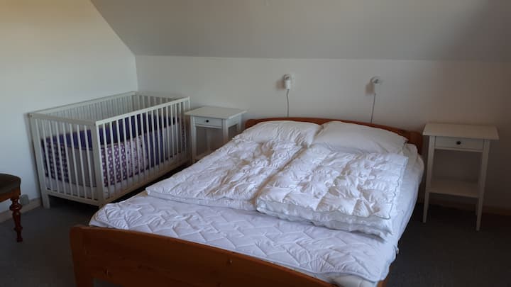 Bedroom with a double bed and a crib