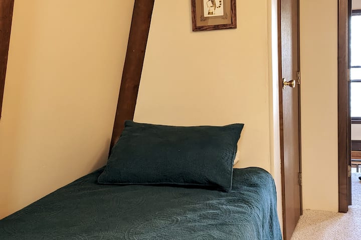 Cama de solteiro no quarto no andar de cima.