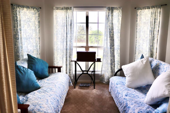 Sunroom off living room with two futons, fan, and french doors for privacy
