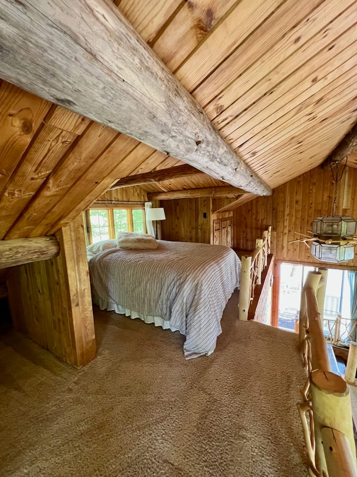 Dormitorio loft con cama tamaño queen.