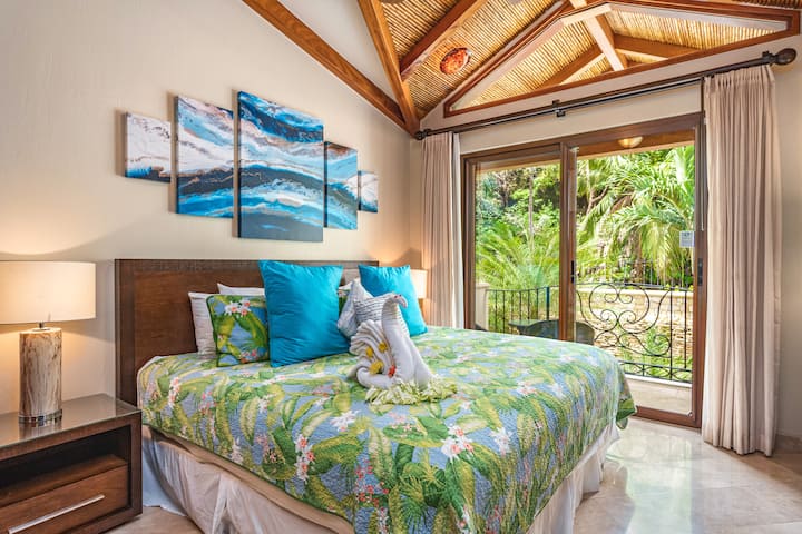The large sliding doors of the Second Bedroom open up to the garden-side patio. Beautiful linens, lamps, and quality furniture make this room extra special.
