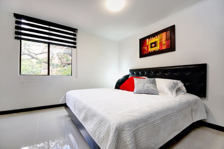 Dhomë gjumi e ndritshme dhe e rehatshme me një krevat dopio "queen" me dritare të gjera