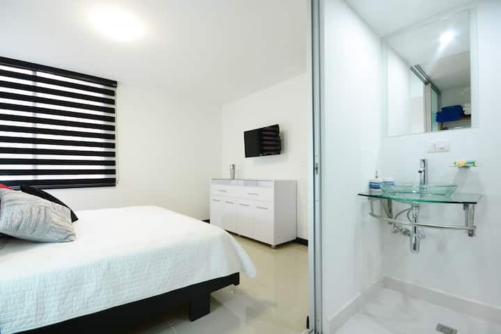 Dhomë gjumi e bollshme me një krevat dopio "queen", një televizor elegant dhe banjë ngjitur dhe dollap me një kasafortë.