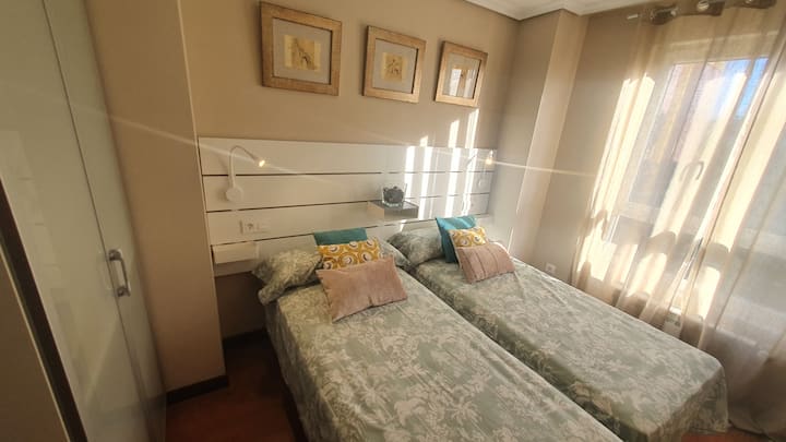 غرفة نوم مزدوجة بسريرين توأمين معًا.