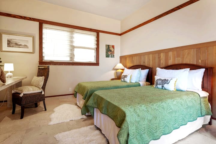 dos camas individuales con ducha y inodoro adyacentes.