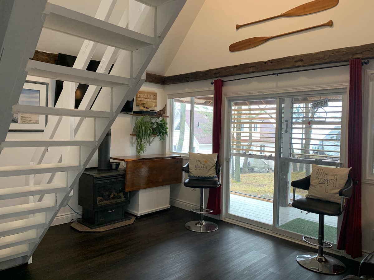 Main living area showing patio doors looking over the lake view and pool with fold-down roll-out dining table