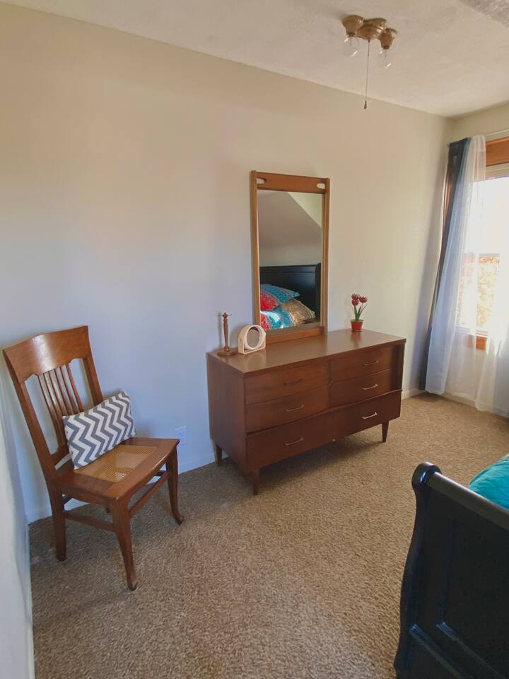 This bedroom includes a walk in closet, dresser and a comfy queen size bed