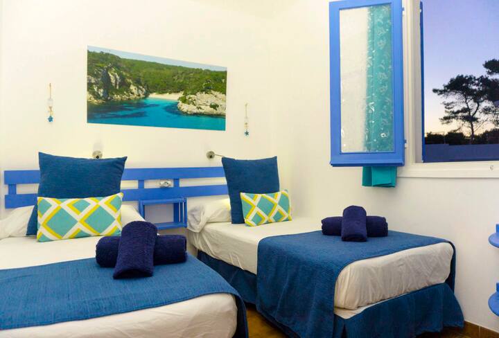 Dormitorio con dos camas individuales, vestido de verano.