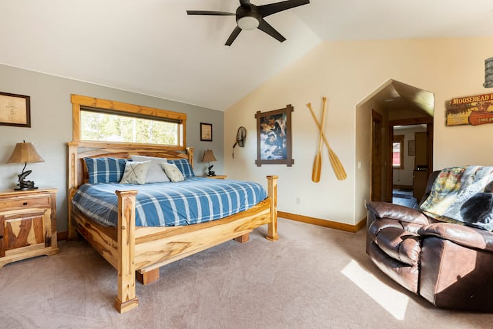 Prostrana glavna spavaća soba na katu s bračnim krevetom, udobnim prostorom za sjedenje i velikom kupaonicom za opuštajući odmor.