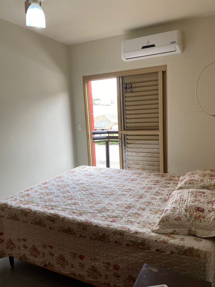 Spálňa s manželskou posteľou so vzduchom, ventilátorom a skrinkami.