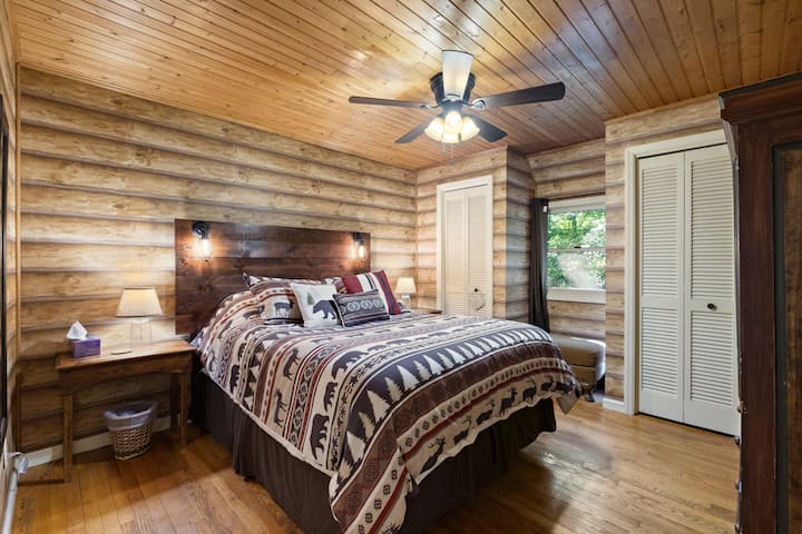 Downstairs queen bedroom with closet and dresser storage, with attached half bath and washer/dryer.