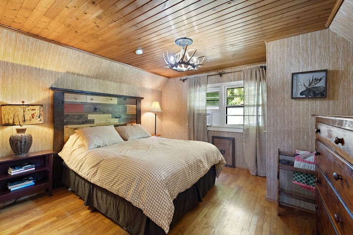 Upstairs queen bedroom with closet and dresser storage. We call this the "antler bedroom" because of the special chandelier. In the cooler seasons, we have an electric fireplace in this room. In warmer times, we have a powerful AC window unit.