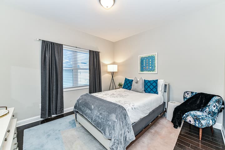 Dormitorio en la planta baja con una cama de tamaño completo y acogedoras mantas.