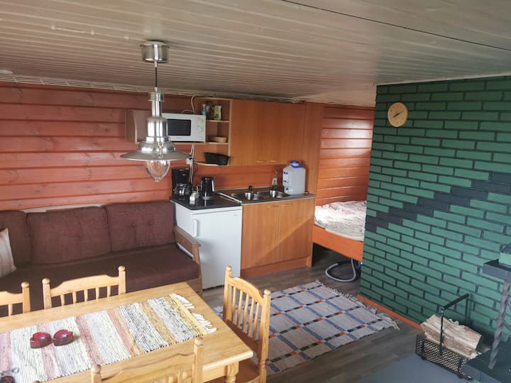 Salón con alcoba y sofá para untar. 
Sala de estar con sofá plegable y cama doble en la esquina.