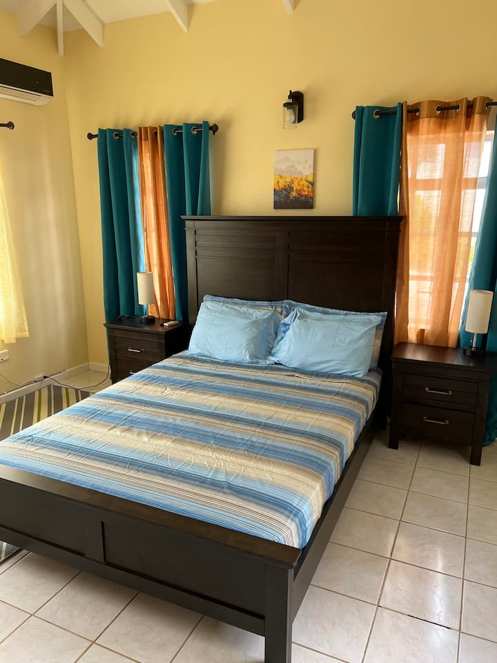 Spare bedroom with Queen size bed, television, air-conditioning.