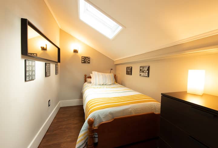 Bedroom with twin bed, skylight and dresser
