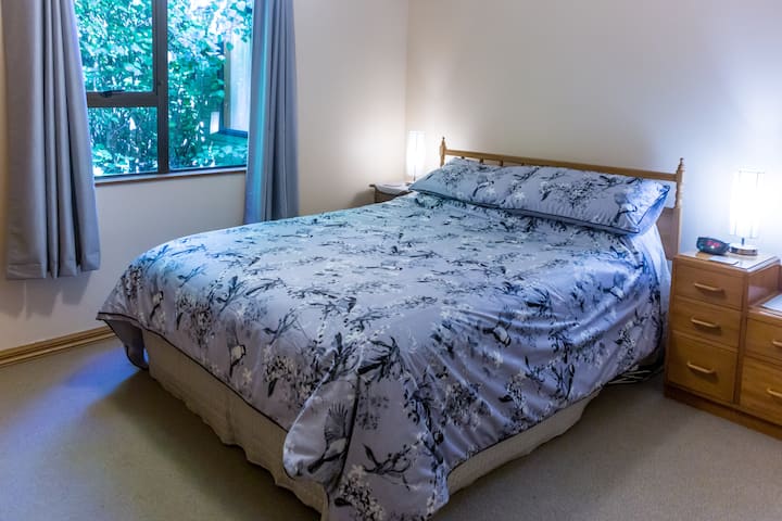 Dormitorio con cama tamaño queen en la planta baja