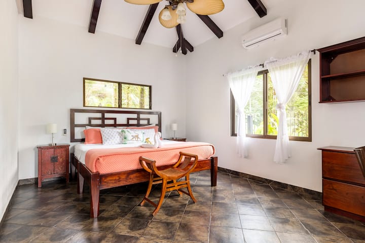 Просторна родителска спалня с двойно легло и малка офис зона.