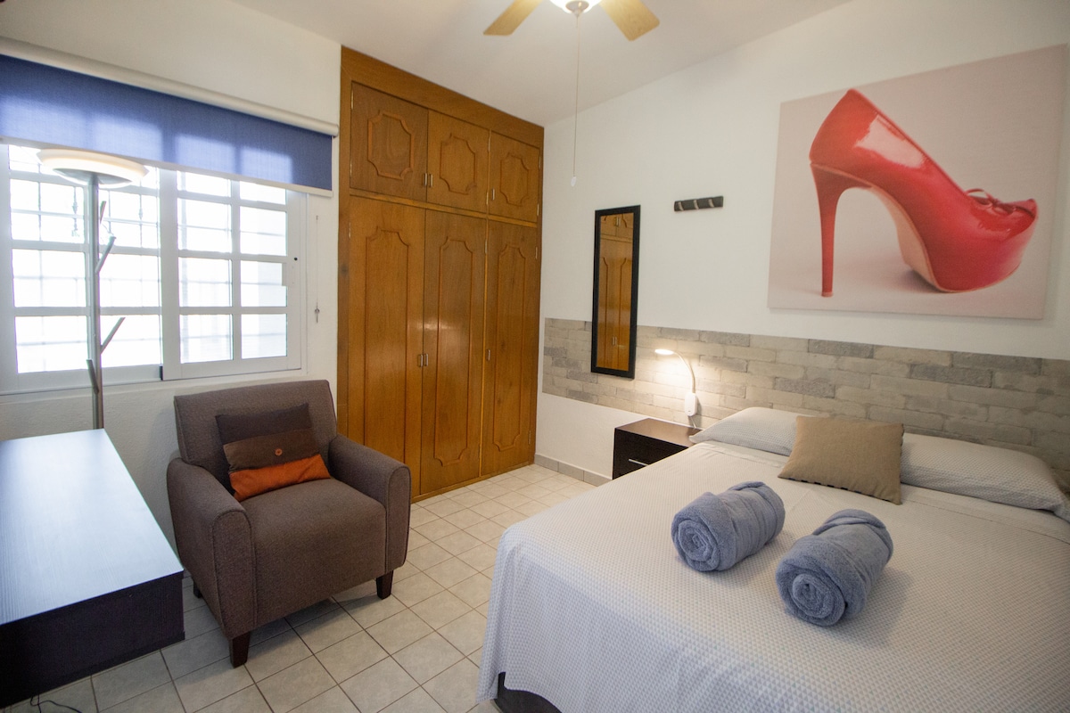 Recamara配有双人床，窗户朝向前露台，配有空调和风扇。