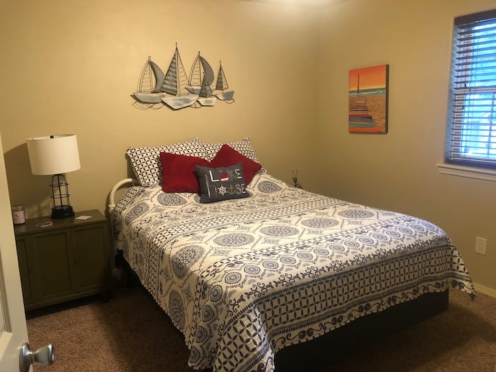 Druhá spálňa má manželskú posteľ s nočným stolíkom a stropným ventilátorom.